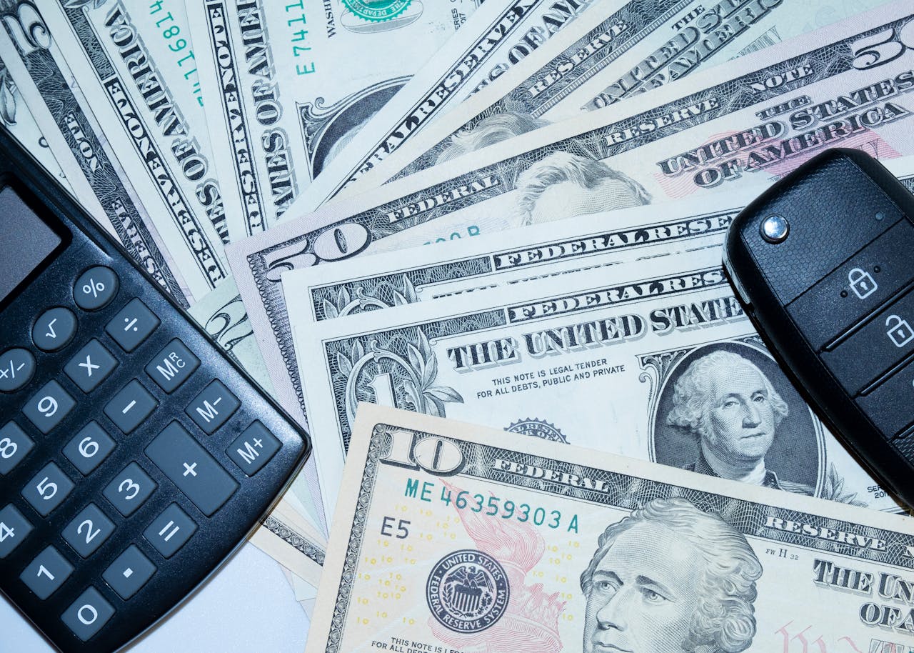 gallery-1 US dollars, calculator, and car keys representing finance and investment tools.