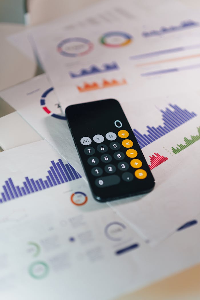 gallery-4 Calculator on graphs showing financial data and analytics. Ideal for business and finance themes.