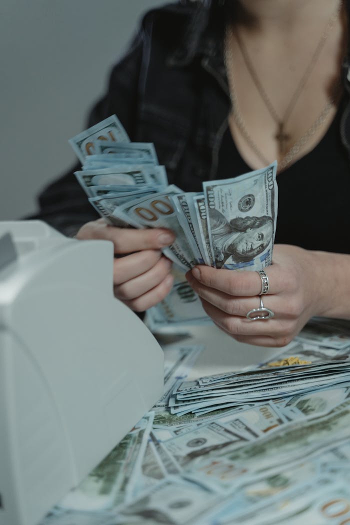 about-01 A woman counting cash with a money counter, symbolizing financial management.